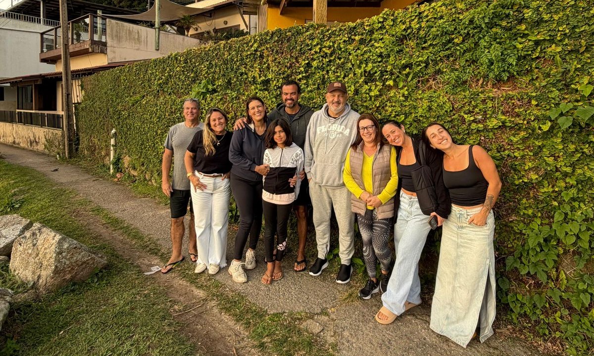 Pessoas em frente ao lindo muro com folhagens.